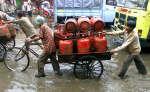 Gas suppliers push their cart through a flooded street in New Delhi. Photo: Reuters/Kamal Kishore