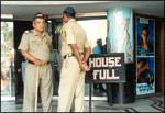 Policemen on guard outside a Bombay cinema hall