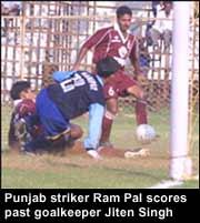 Punjab striker Ram Pal scores past goalkeeper Jiten Singh